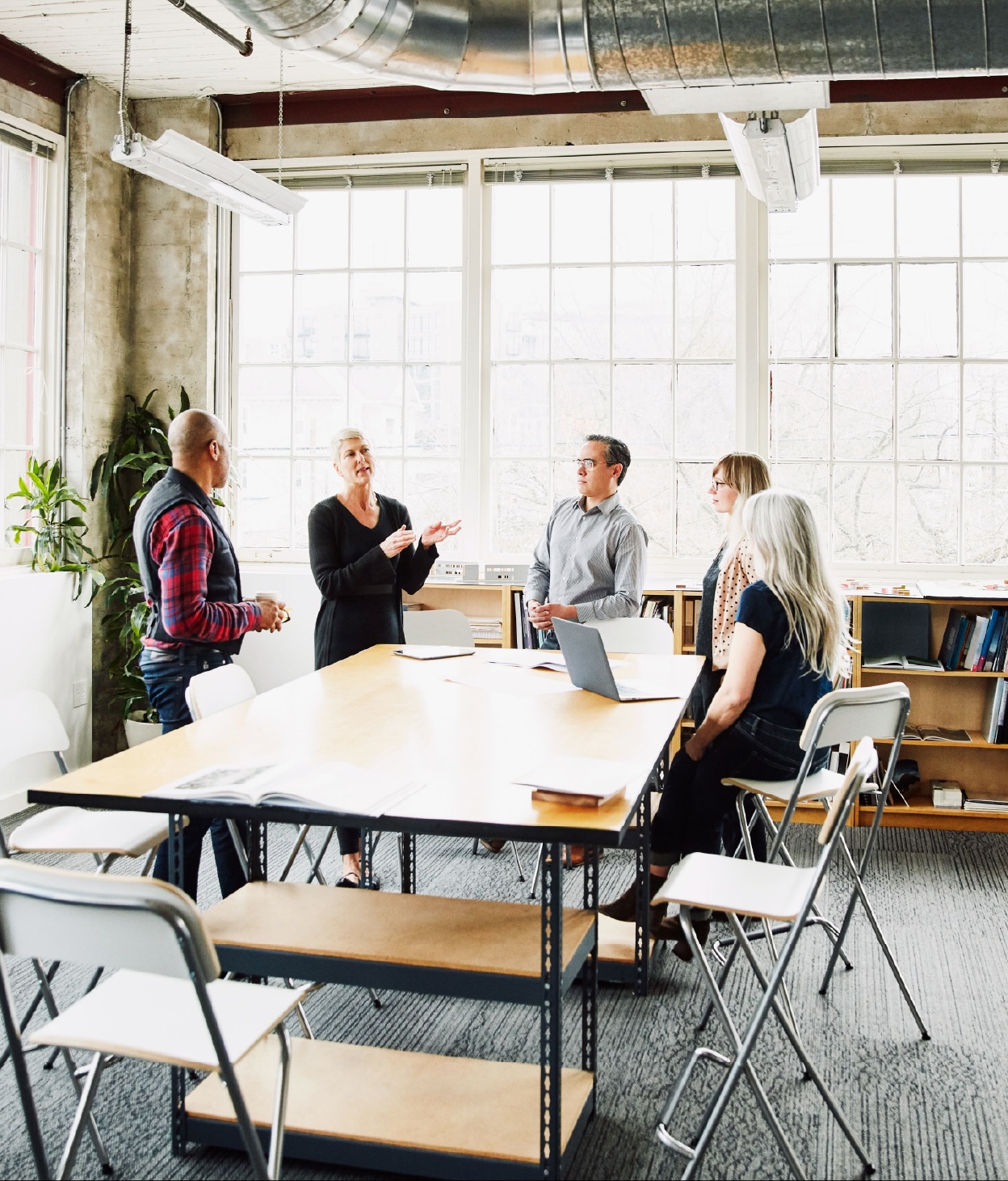 Teammates having a conversation around a meeting table.
