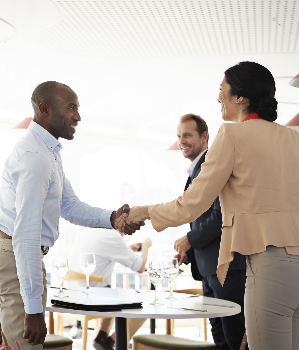 Businessman greeting potential clients at a restaurant 